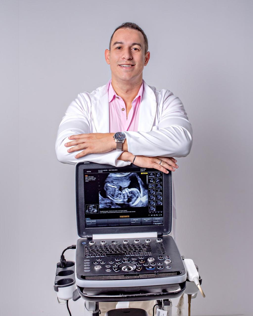 Dr. Neto Ribeiro sorrindo em jaleco branco com transdutor de ultrassom